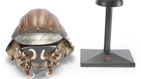 A professional image of the Lando Calrissian Skiff Guard helmet collectable sitting next to its display stand