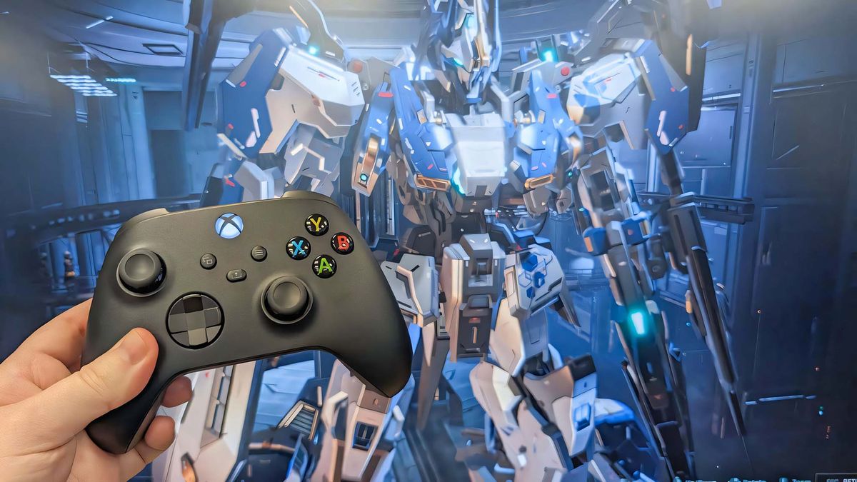 An Xbox controller being held up in front of a screen that&#039;s displaying Mecha BREAK. 