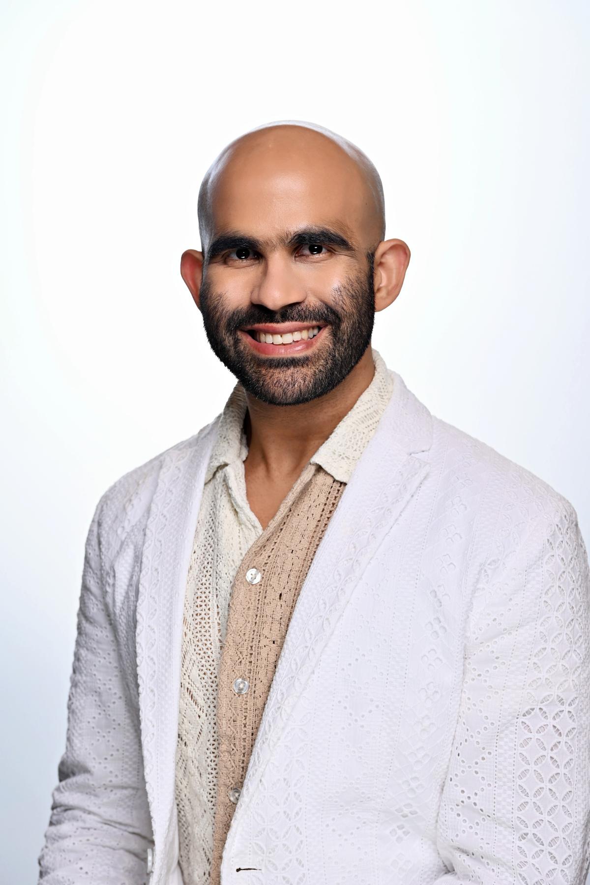 Dr. Karan Lal in a embroidered suit smiling at the camera