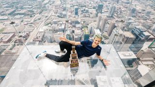 Ninja poses with a trophy at the top of Willis Tower. 