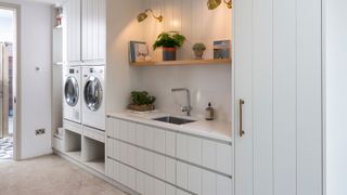 utility room with sink, washing machine, tumble dryer and plentiful storage