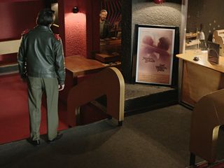 Image of a still from the film 'The secret Agent'- A man stood at the top of a few steps by the box office at the cinema/theatre