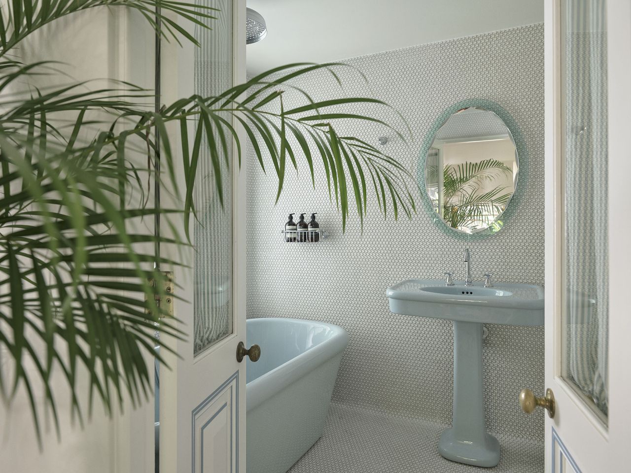An all over tiled bathroom with blue pastel ceramic accents