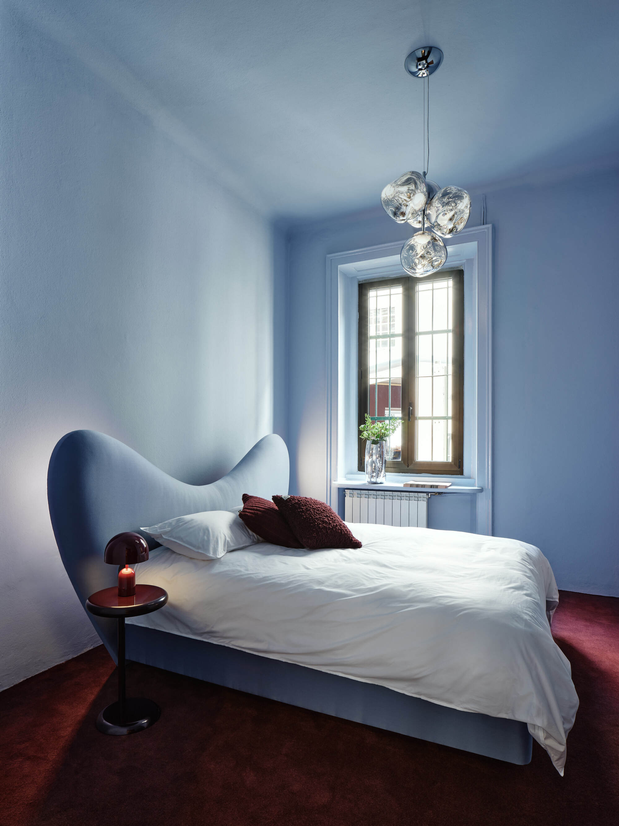 A bedroom color drenched in a light blue shade with a contemporary style double bed the same shade