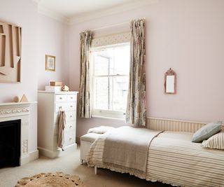 children's room decorated in neutral shades with single bed, chest of drawers and patterned curtains