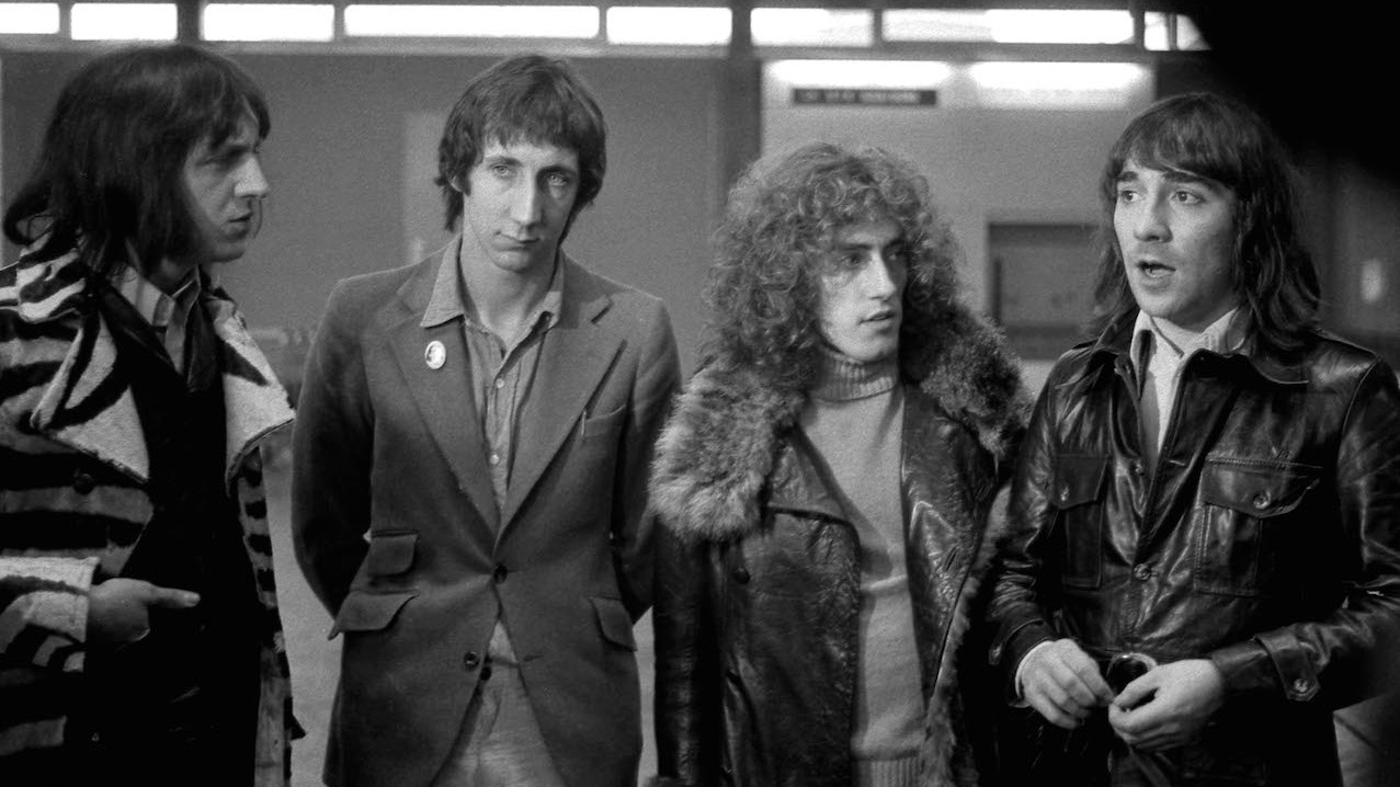 The Who standing in a row looking pensive.