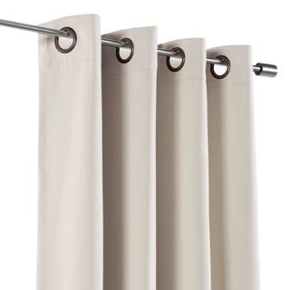 Biscuit colored black out curtains on a silver rail