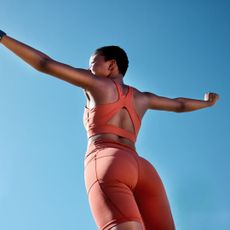 How to get toned arms: A woman in working kit against a blue sky