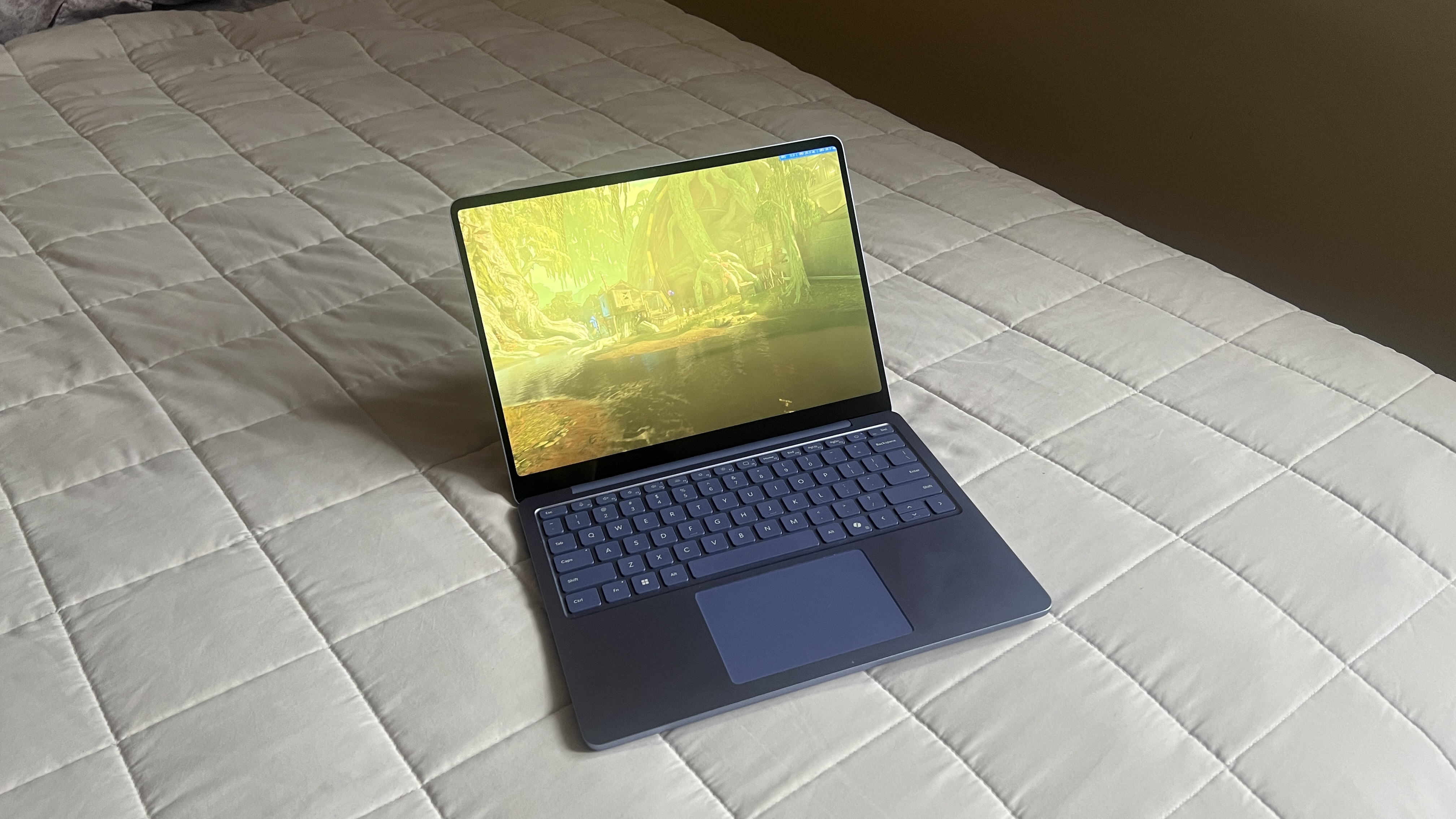 A Microsoft Surface Laptop 13-inch on a bed
