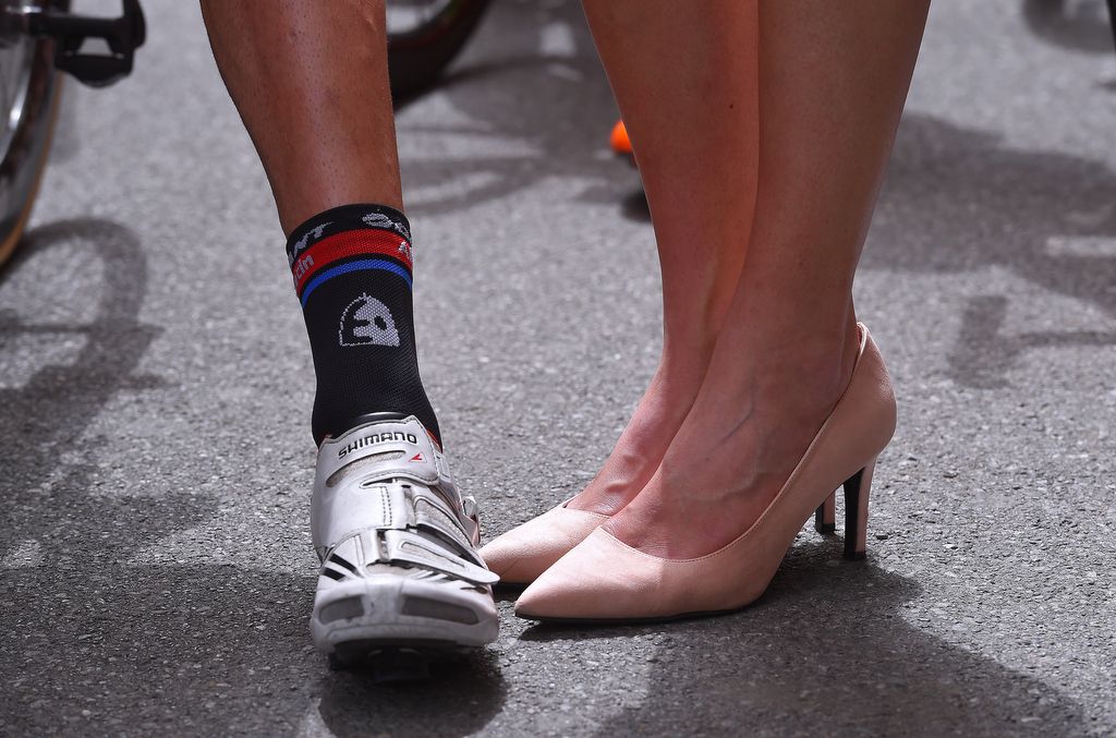 Contrasting shoes and legs of Tom Dumoulin and the hostesses
