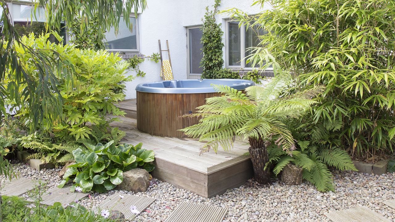 Hot tub on a raised decking area surrounded by lush foliage