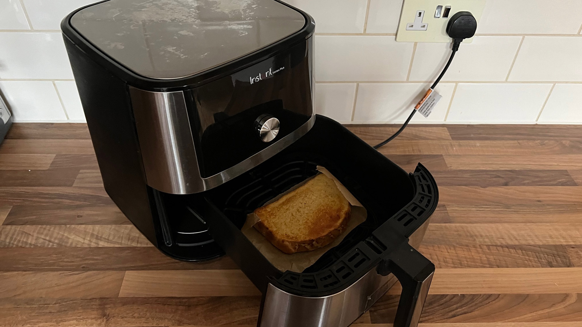 Instant Vortex Plus dengan French Toast di atas secarik kertas roti di laci penggorengannya