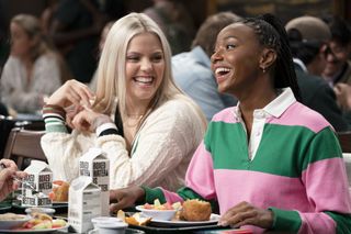two women (Reneé Rapp and Alyah Chanelle Scott) laugh while eating lunch, in 'the sex lives of college girls' season 2