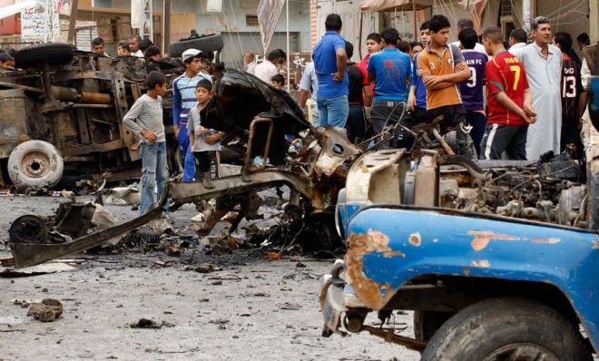 People inspect the scene of a car bomb attack