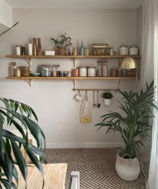 wooden shelving unit with food containers and hanging rails in a dining room