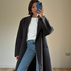 Woman in gray coat, white t-shirt and jeans