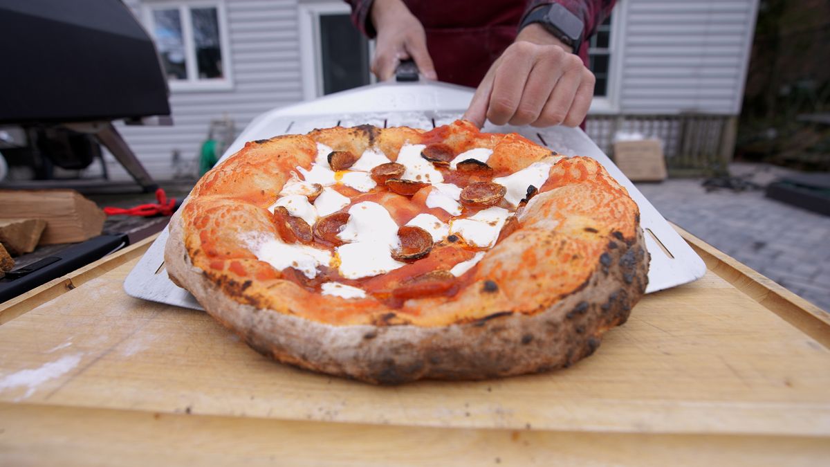 Pizza coming out of oven