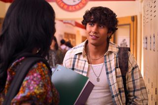 Ethan talking to Devi in the school hallway