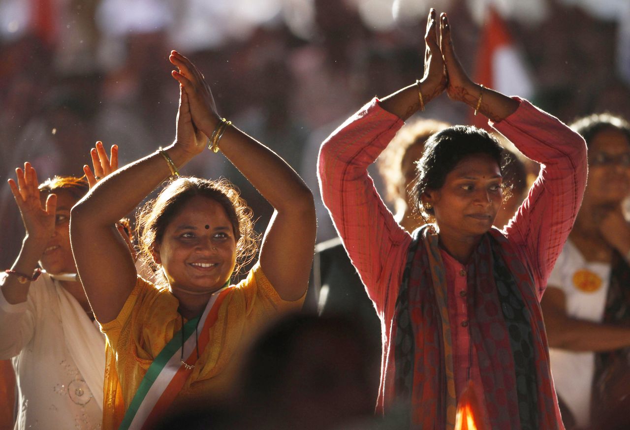 A pair of Indian women practice yoga.