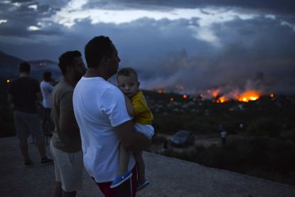 Wildfires burn near Athens as locals watch from a distance