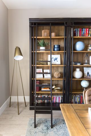 A home office with a standing lamp in the corner