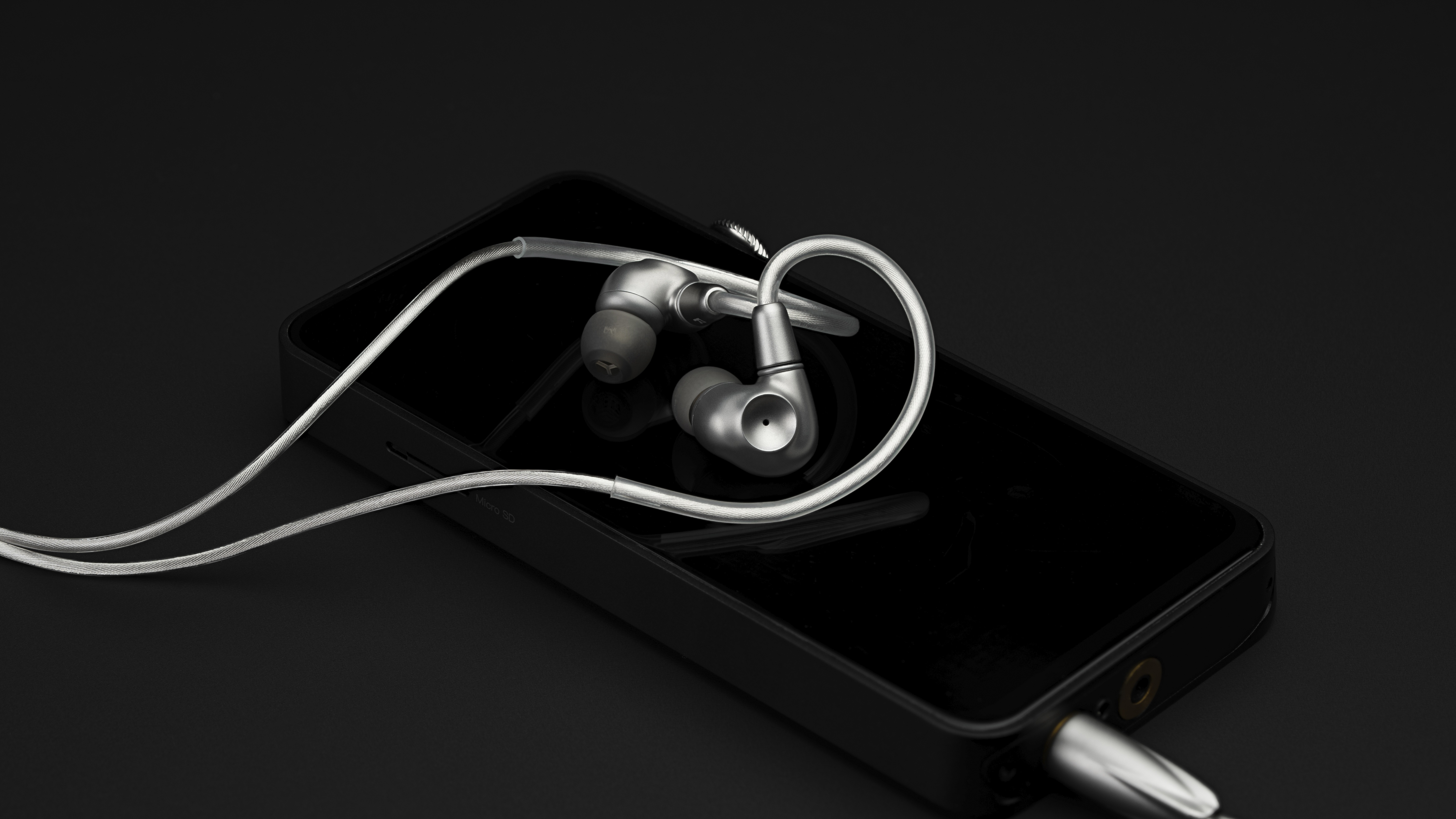 Meze Astru wired in-ear headphones in silver on a smartphone