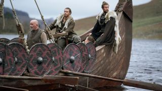 Sam Corlett, Lujza Richter, and Leo Suter sailing on a viking ship in Vikings: Valhalla.