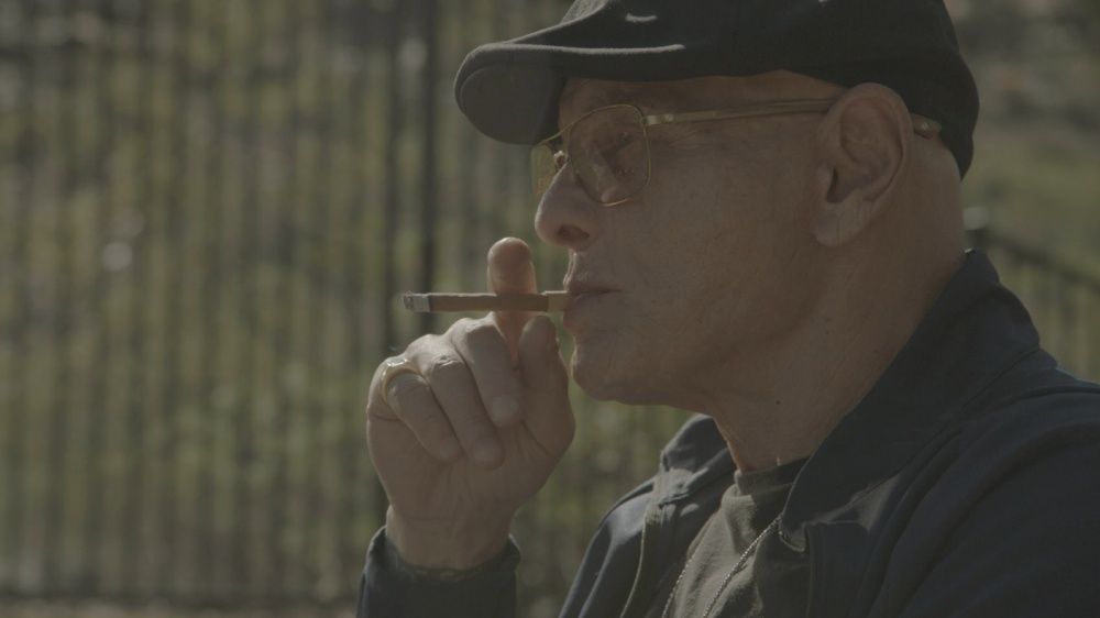 Salvatore “Sammy the Bull” Gravano wearing a flatcap and smoking a cigarette in Sons of Ecstasy