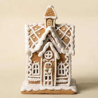 Lighted Gingerbread House against a cream background.