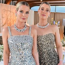 Amelia and Eliza Spencer wearing sequined dresses and diamonds standing in front of a dinner table