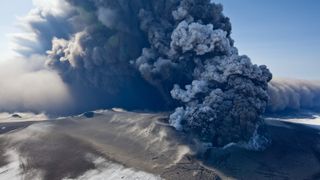 A massive plume of smoke and ash rising from a volcano