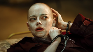 Emma Stone bald and handcuffed with white cream all over her face and head in Bugonia