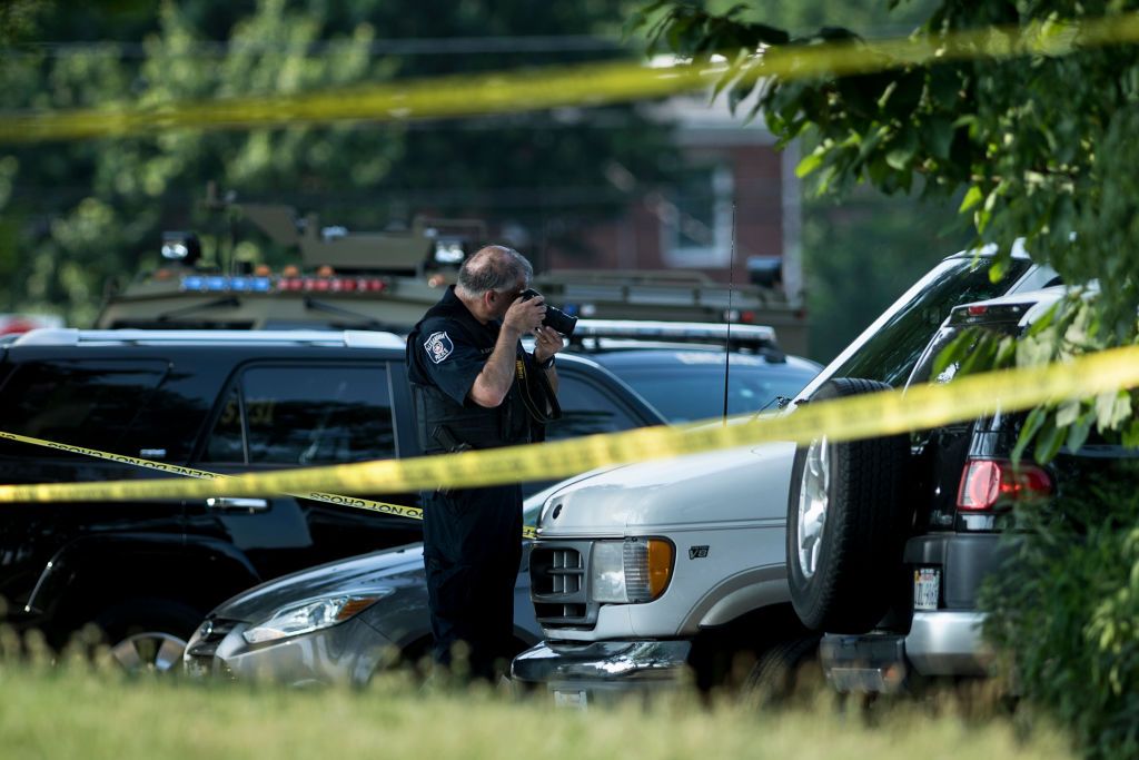 Officer photographing scene of shooting.