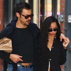 Zoe Kravitz and Harry Styles walking in NYC wearing black tops and jeans