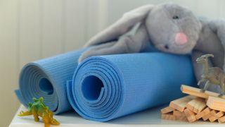 Two yoga mats leaning against each other with children's toys next to them