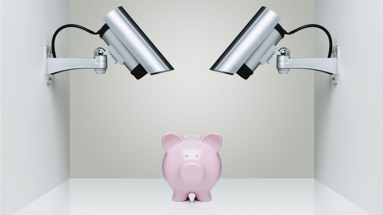 A piggy bank sits under security spotlights.