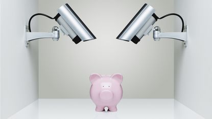 A piggy bank sits under security spotlights.