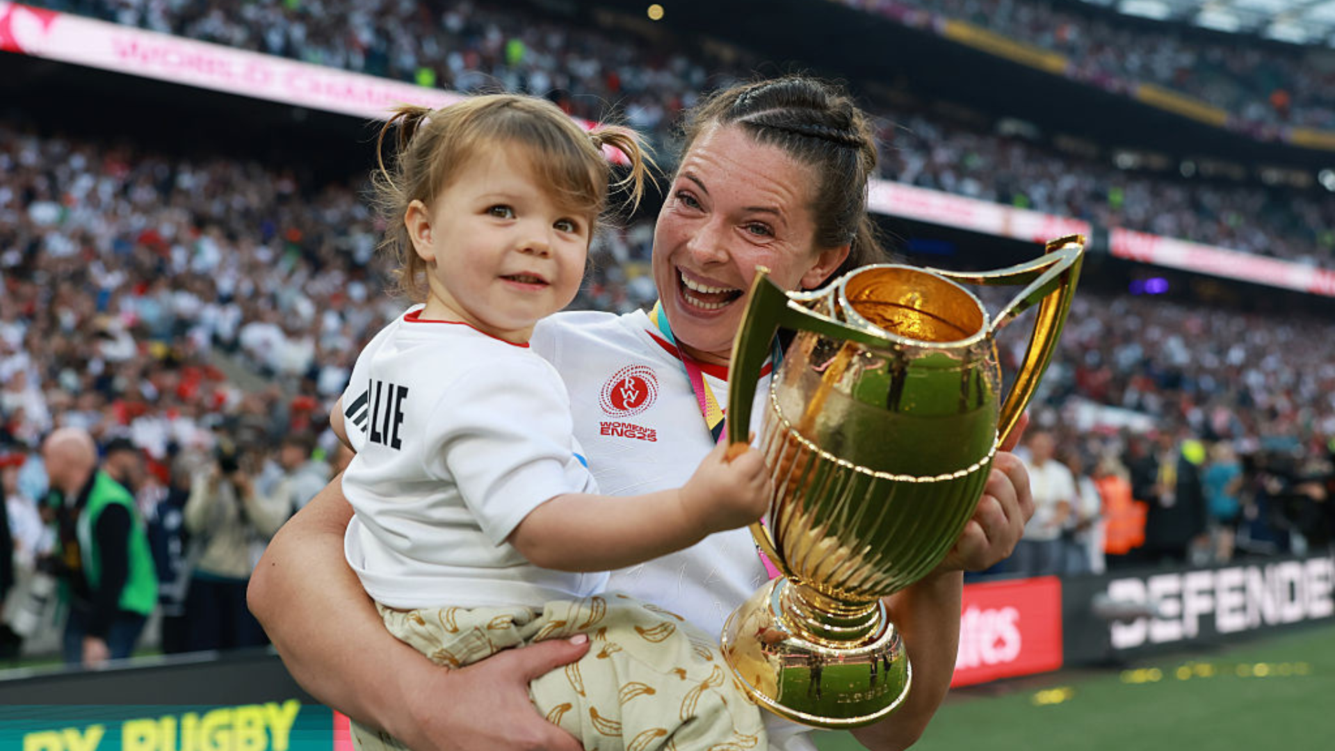 Abbie Ward of England holds the Women&#039;s World Cup Trophy with her daughter Hallie following the Women&#039;s Rugby World Cup 2025 Final match between Canada and England at Allianz Stadium on September 27, 2025 in London, England. (Photo by Alex Davidson - World Rugby/World Rugby via Getty Images)