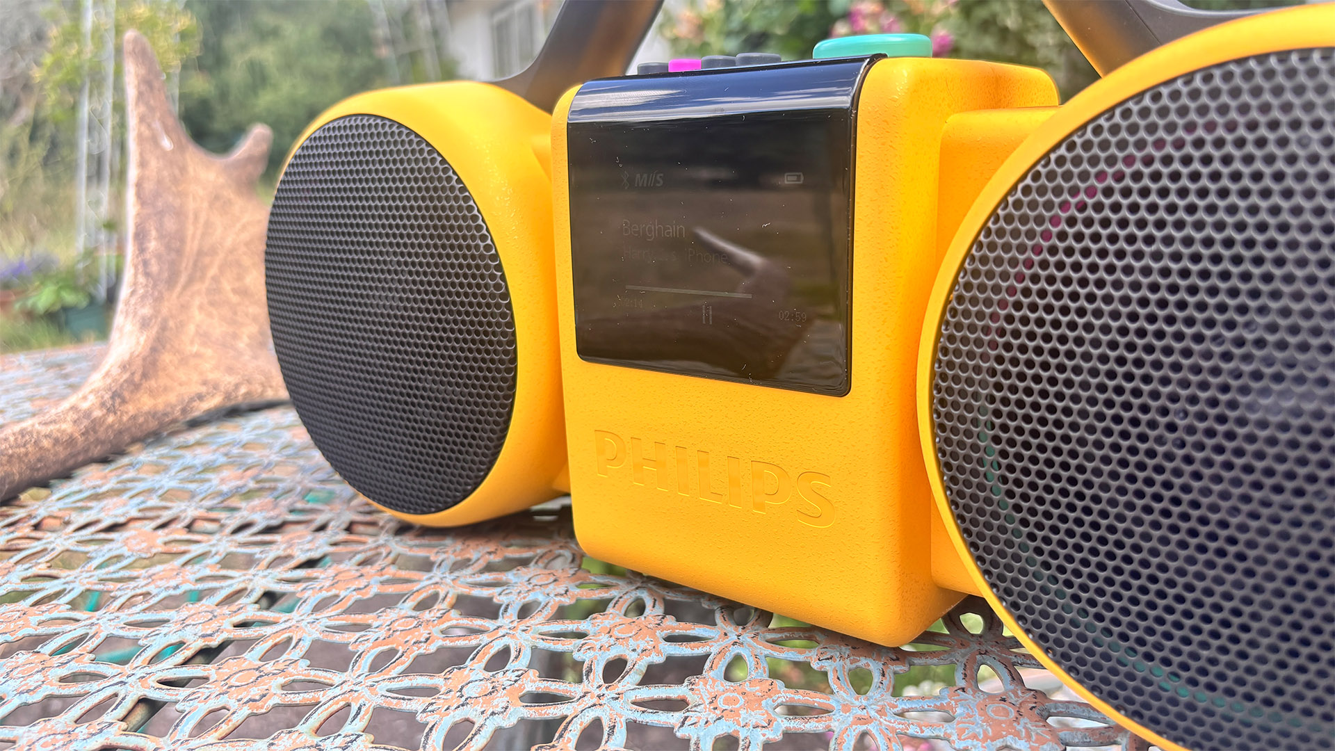 Philips The Roller wireless speaker on metal garden table