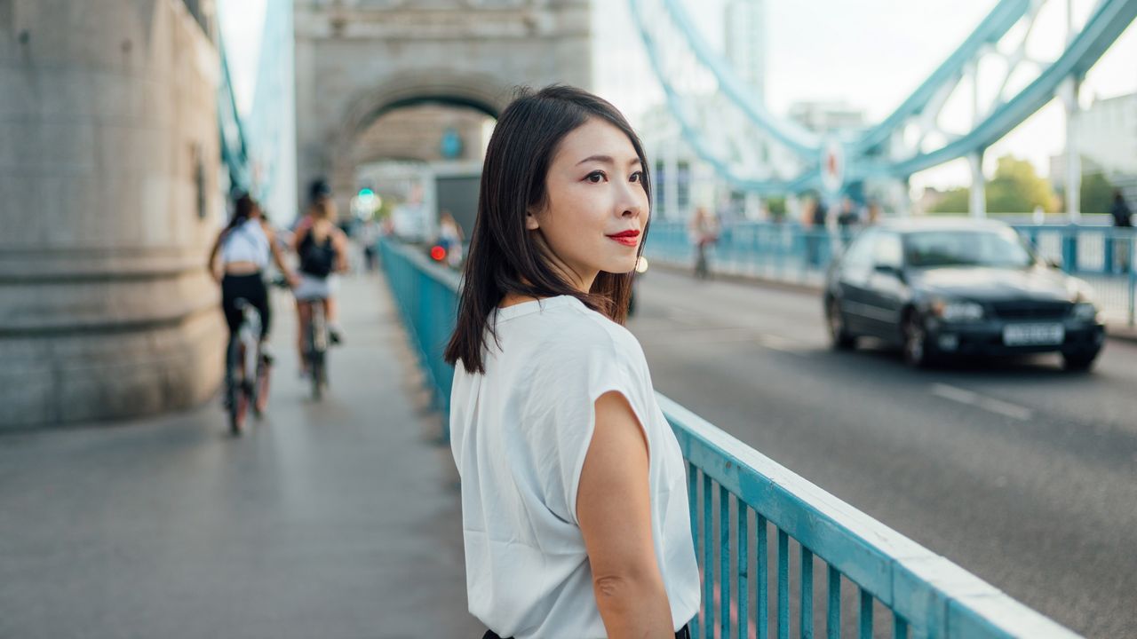 A businesswoman looks back over her shoulder while walking outside.