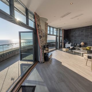 living room with balcony and grey windows