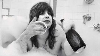 Ozzy Osbourne in a bubble bath with champagne and a cigar