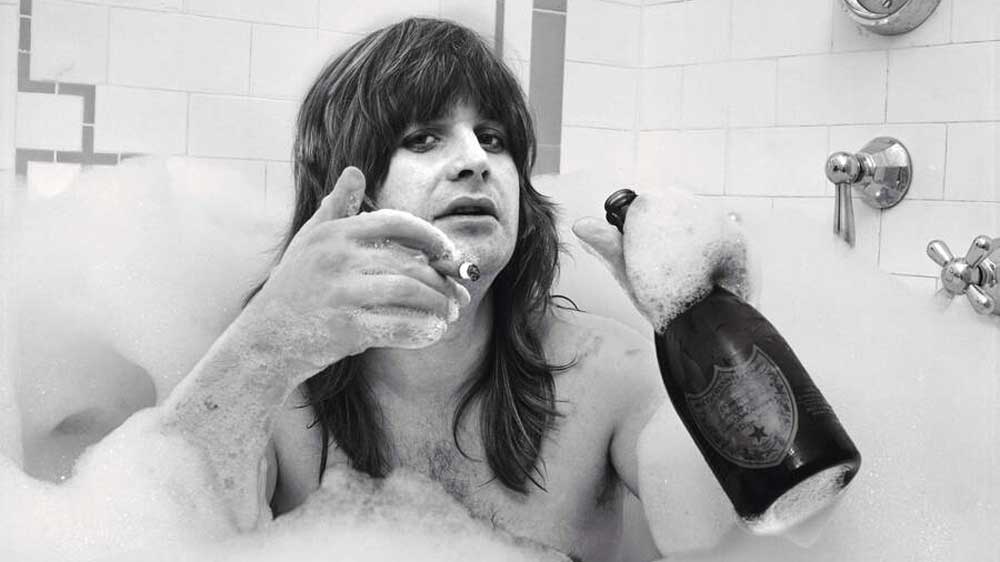 Ozzy Osbourne in a bubble bath with champagne and a cigar