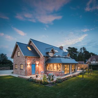An oak frame home with the lights on