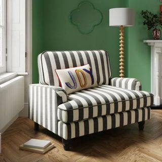 black and white striped snuggle chair in green room