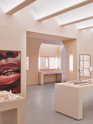 New York Glossier store interior in nude shades, with poster of lips on wall