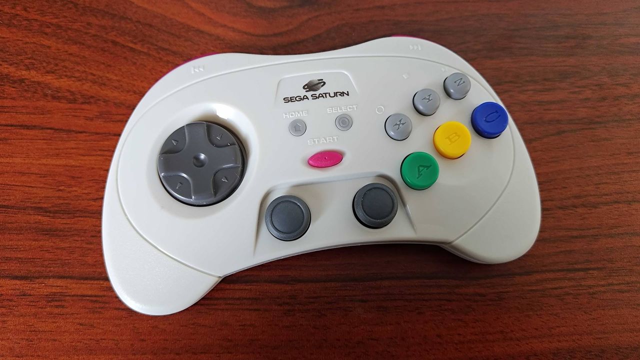 Retro-bit Sega Saturn controller lying on woodgrain desk