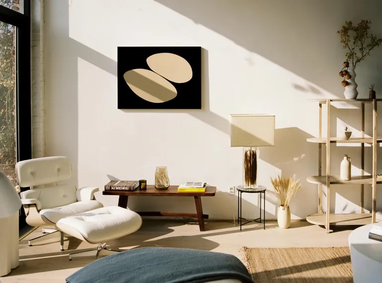 Biscuit Loft by OWIU - Sun rays shine in a beige room with various minimalist furniture.