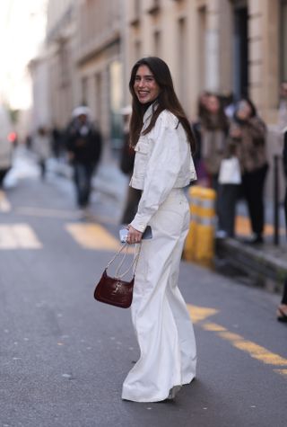 Belen Hostalet was seen wearing brown bag, cropped white jeans jacket as well as white denim jeans outside before Zimmermann Fashion Show during the Womenswear Fall/Winter 2024/2025 as part of Paris Fashion Week on March 04, 2024 in Paris, France.