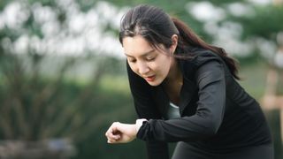 Young woman checking sports watch after a run